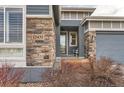 Front entrance with stonework, a glass door, and a wooden planter at 12432 Meadowlark Ln, Broomfield, CO 80021