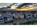 Exterior rear view of home showcasing lush landscaping, and a covered patio area, at sunset at 15788 Valentia St, Thornton, CO 80602