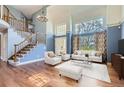 Elegant living room with high ceilings, large windows, and an open staircase, creating a bright and inviting space at 15976 Quarry Hill Dr, Parker, CO 80134
