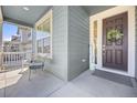 Cozy front porch featuring seating, a welcome sign, and a decorated front door at 806 Cabot Dr, Erie, CO 80516
