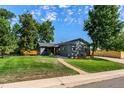 Well-maintained front yard and gray single-story home with a sidewalk to the front door at 5601 E Colorado Ave, Denver, CO 80224