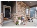 Inviting covered porch adorned with stone accents and decorated with charming rustic elements at 7227 Clarke Dr, Frederick, CO 80530
