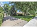 Side exterior home view exhibiting a driveway and mature trees at 1091 E Pinewood Ave, Centennial, CO 80121