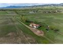 Sprawling aerial view of property surrounded by beautiful green land and mountains at 8602 N 39Th St, Longmont, CO 80503