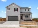 Two-story home featuring a gray exterior, brick accents, and a two-car garage at 8819 Sedalia St, Commerce City, CO 80022
