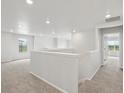 A bright and spacious loft area with neutral carpet, recessed lighting, and white walls at 8819 Sedalia St, Commerce City, CO 80022