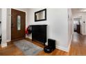 Inviting entryway with hardwood floors, stylish storage cabinet, and a beautiful wood door with decorative glass at 585 Estes St, Lakewood, CO 80226