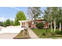 Charming brick home with well-maintained front yard, covered porch, mature trees, and an attached two-car garage at 6535 Balsam St, Arvada, CO 80004