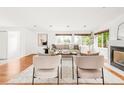 Well-lit living room with hardwood floors, a cozy fireplace, stylish seating, and views of the outdoors through large windows at 6535 Balsam St, Arvada, CO 80004