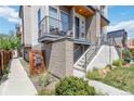 Modern townhome entrance with a balcony, showcasing contemporary design and well-maintained landscaping at 2409 Court Pl, Denver, CO 80205