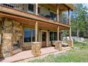 Outdoor patio featuring a stone fireplace, comfortable seating, and a spacious covered area for entertaining guests at 1555 Three Peaks Rd, Golden, CO 80403