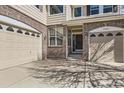 Spacious home with a three-car garage, brick accents, and a covered entrance at 24763 E Crestridge Pl, Aurora, CO 80016