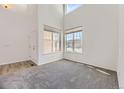 Bright living room with high ceilings, large windows, and neutral carpet at 24763 E Crestridge Pl, Aurora, CO 80016