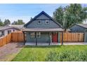 Charming home featuring a well-maintained lawn, cozy porch, and vibrant red front door at 2310 S Decatur St, Denver, CO 80219