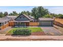 Inviting home with a well-manicured lawn, detached garage, and classic curb appeal at 2310 S Decatur St, Denver, CO 80219