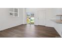 Sunlit living room featuring wood-look flooring, white walls, and sliding door access at 681 N Tempe St, Aurora, CO 80018
