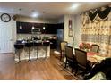 Open kitchen boasts dark cabinetry, stainless steel appliances, and a breakfast bar overlooking the dining area at 15600 Bolling, Denver, CO 80239