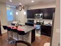 Well-lit kitchen featuring stainless steel appliances, granite countertops, and barstool seating at the island at 15600 Bolling, Denver, CO 80239