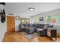 Inviting living room featuring hardwood floors, a comfortable gray sectional, and an abundance of natural light at 6031 S Pennsylvania St, Centennial, CO 80121