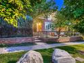 Charming two-story brick home with lush landscaping, rock detail, and a cozy front patio at 338 Saint Paul St, Denver, CO 80206