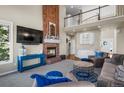 Open-concept living room with brick fireplace and view of second story at 3603 Soaring Eagle Ct, Castle Rock, CO 80109
