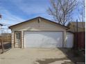 A detached two-car garage with an additional side door and a white garage door at 5660 Olive St, Commerce City, CO 80022