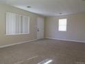 Bright and airy living room with neutral walls, new carpet, and two large windows with views of the exterior at 5660 Olive St, Commerce City, CO 80022