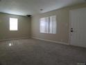 Bright living room featuring neutral colored walls, carpet, and large windows that let in ample natural light at 5660 Olive St, Commerce City, CO 80022