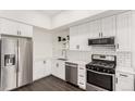 Bright kitchen featuring stainless steel appliances, white cabinets, and a modern subway tile backsplash at 2876 W 53Rd Ave # 111, Denver, CO 80221