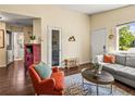 Cozy living room featuring an orange armchair, grey sofa, decorative rug, and stylish furnishings at 4453 S Pagosa Way, Aurora, CO 80015