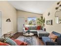 Cozy living room featuring a plush sectional couch, plants, and a view of the backyard at 4453 S Pagosa Way, Aurora, CO 80015