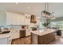 Well-lit kitchen with custom cabinets, center island, stainless steel appliances, and wood flooring at 3487 Willownook Ranch Trl, Elizabeth, CO 80107
