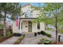 Beautiful home featuring a quaint covered porch, green door, and manicured landscaping with an American flag at 4508 Lowell Blvd, Denver, CO 80211