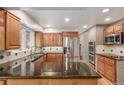 Spacious kitchen featuring granite countertops, stainless steel appliances, and brick accent wall at 3 Glenview Dr, Littleton, CO 80123