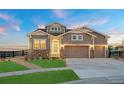 Charming home with stone accents, a three-car garage, and a beautifully landscaped front yard at 23696 E Del Norte Pl, Aurora, CO 80016
