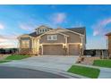 A craftsman style home with a three-car garage, stone accents, and a well-manicured lawn at 23696 E Del Norte Pl, Aurora, CO 80016
