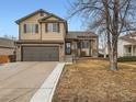 Charming two-story home featuring stone accents, a two-car garage, and manicured landscaping at 11395 E 116Th Dr, Commerce City, CO 80640