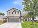 Inviting two-story home featuring a well-manicured lawn and a spacious driveway leading to a two-car garage at 11395 E 116Th Dr, Commerce City, CO 80640
