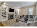 Comfortable living room featuring a cozy fireplace, built-in shelving, and a plush gray sectional sofa at 3810 Cadence Dr, Castle Rock, CO 80109