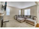 Bright living room with a large gray sectional sofa, a modern fireplace, and natural light from the large windows at 3810 Cadence Dr, Castle Rock, CO 80109