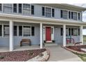 Inviting front porch with seating, a red front door, and decorative landscaping, creating a warm and welcoming entrance at 35427 Welch Trl, Elizabeth, CO 80107