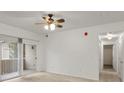 Bright living room features a sliding glass door to the balcony and neutral carpeting at 912 S Yampa St # 203, Aurora, CO 80017