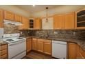 Kitchen with light wood cabinets, granite countertops, and appliances at 2896 W Riverwalk Cir # 204, Littleton, CO 80123