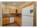 Kitchen with light wood cabinets, granite countertops, and appliances at 2896 W Riverwalk Cir # 204, Littleton, CO 80123