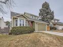 Two-story house with green siding, attached garage, and American flag at 2368 W 119Th Ave, Denver, CO 80234