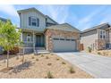 Charming two-story home with a stone facade, gray siding, and a welcoming front porch and a well manicured yard at 1889 Water Birch Way, Castle Rock, CO 80108