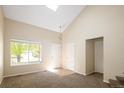 Bright living room featuring vaulted ceilings, a large window, and neutral carpet flooring at 4860 W 125Th Ave, Broomfield, CO 80020
