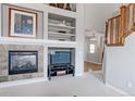Comfortable living room featuring a fireplace, built-in shelves, and staircase at 14214 Lakeview Ln, Broomfield, CO 80023
