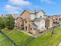 Beautiful multi-story townhouse boasting stone and siding exterior, set on a well-maintained lawn with dark metal fencing at 18601 E Water Dr # A, Aurora, CO 80013