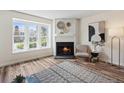 Cozy living room featuring a fireplace, large window, and modern decor at 9636 W Chatfield Ave # C, Littleton, CO 80128